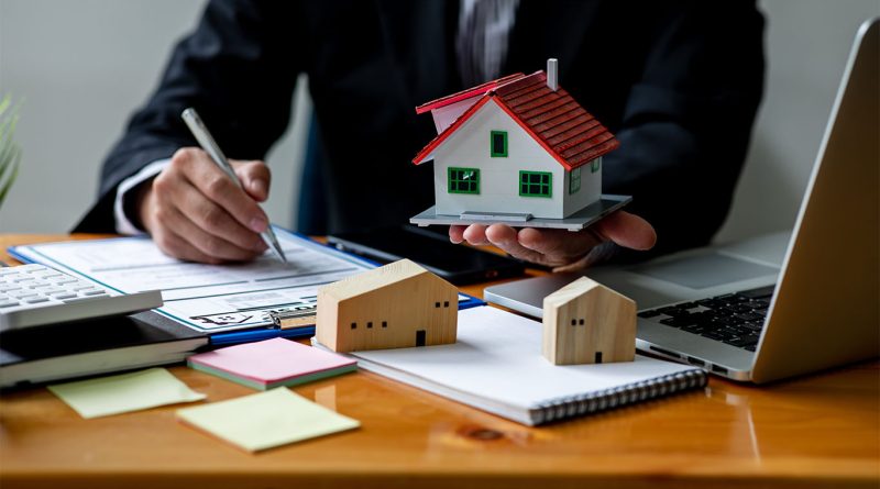 Image of a person holding a model house to support assumable mortgages article