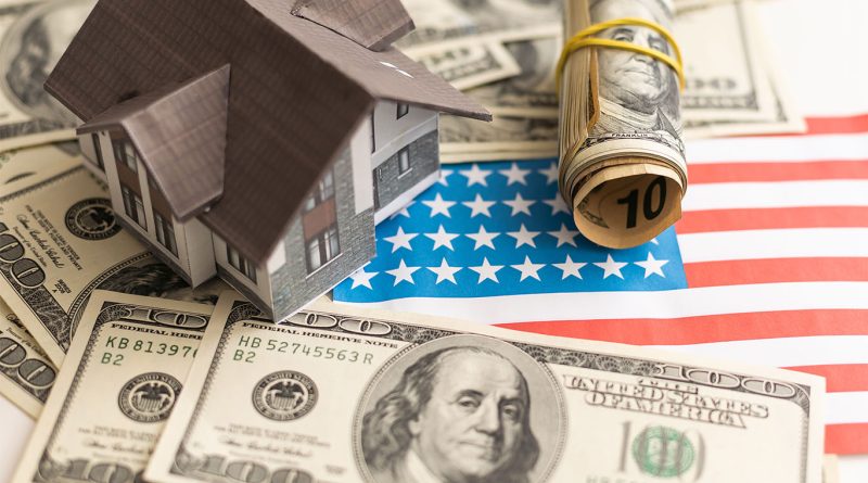 Image of some U.S dollars and a model house on a table to support us housing market crisis article