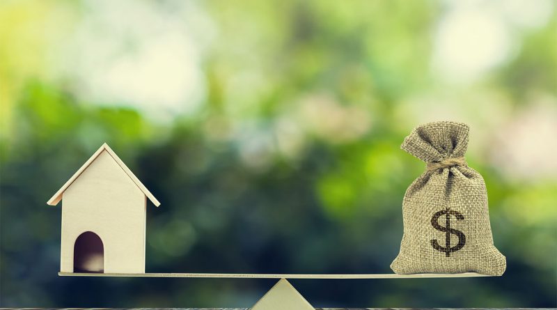 Image of a weighing scale, with a model house one side and a bag of money the other to support affordable homes article