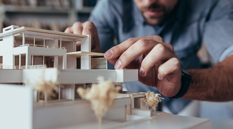 Architect working on a modern luxury home model, representing the design precision of top US luxury home builders.