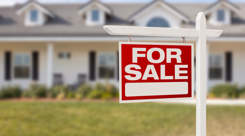 A neighborhood of houses with a for-sale sign, symbolizing the rising cost of housing in the United States in 2025