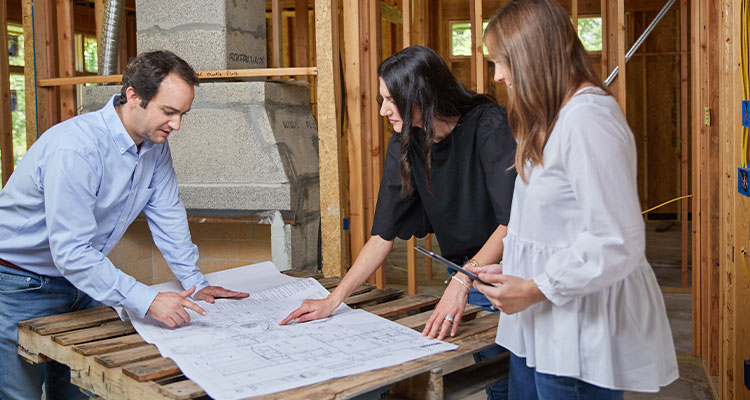 Byron Beavers from Byron Beavers Construction looking over plans with clients