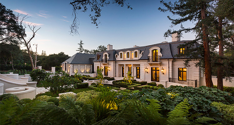 a large, luxurious two-story house with a French-inspired architectural style