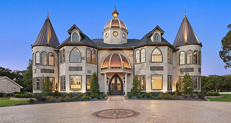 a large, castle-like house with a light-colored facade, multiple turrets with dark conical roofs, and a central domed entrance