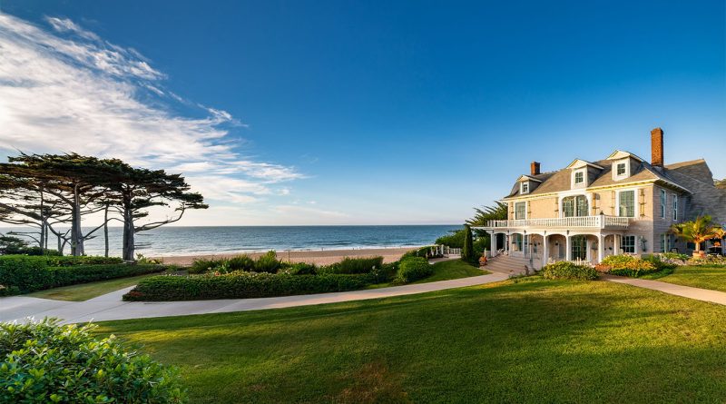 A historic farmhouse style mansion with blue shutters set in the Hamptons, recently relisted by Alec Baldwin