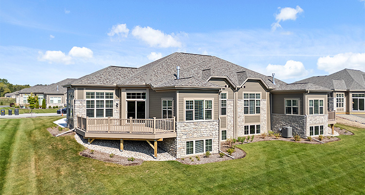 the rear view of a large, contemporary two-story house on a bright, sunny day.