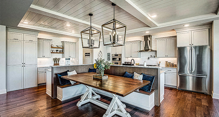 a transitional-style kitchen with a built-in banquette seating area and a large wooden trestle table