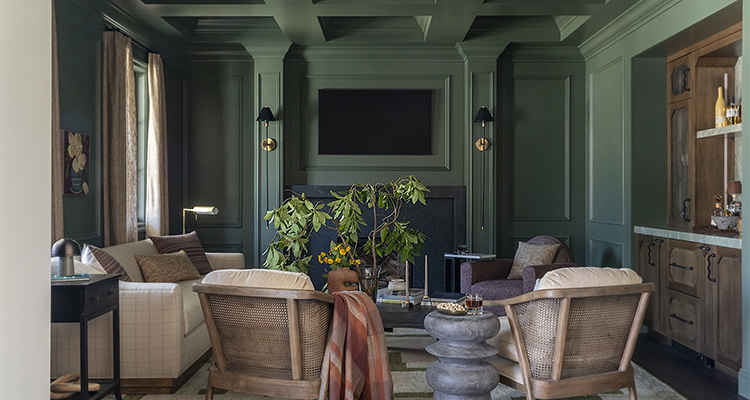 a cozy and sophisticated living room with a reading nook area, characterized by a moody, dark green color palette on the walls and ceiling