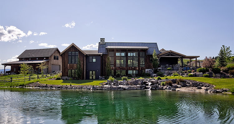 a luxury mountain-style home with a dark wood exterior
