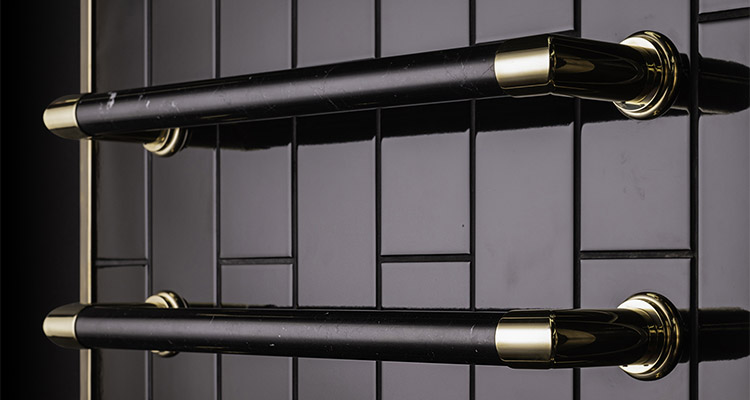 an electric towel warmer with black marble rails and brass fittings.