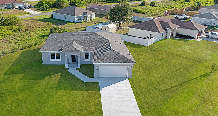 a single-story house with a light gray exterior and a gray shingled roof.