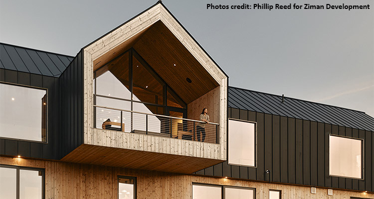 A contemporary structure with a striking contrast between the dark metal cladding on the main body and the natural wood siding